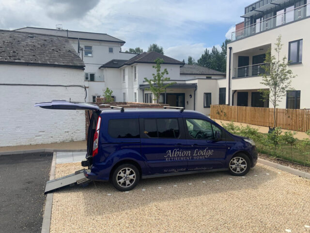 A vehicle parked on stabilised gravel beside the Albion Meadows apartments.