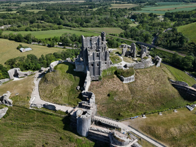 Aerial view of Corfe Castle and the surrounding Dorset countryside.