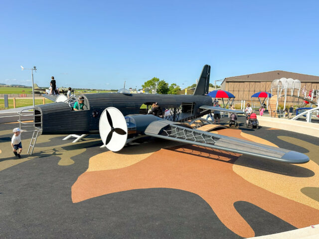 Aircraft-themed play structure surrounded by colourful surfacing at IWM Duxford.