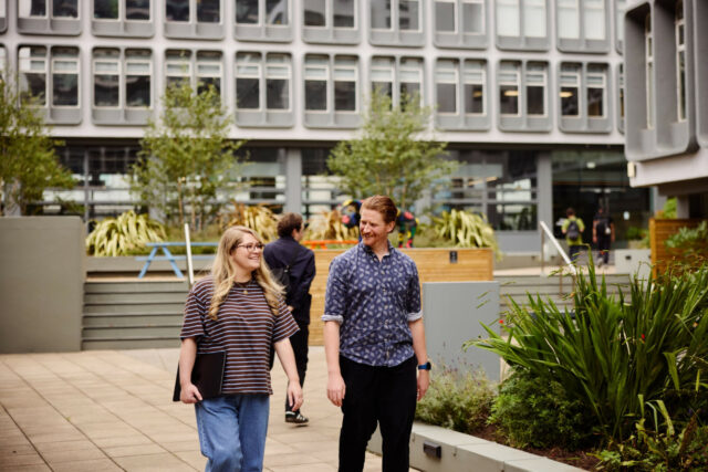 People walking through the planted courtyard at Riverside, Salford.